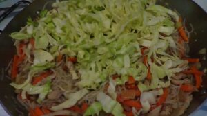 Adding the cabbage and carrots